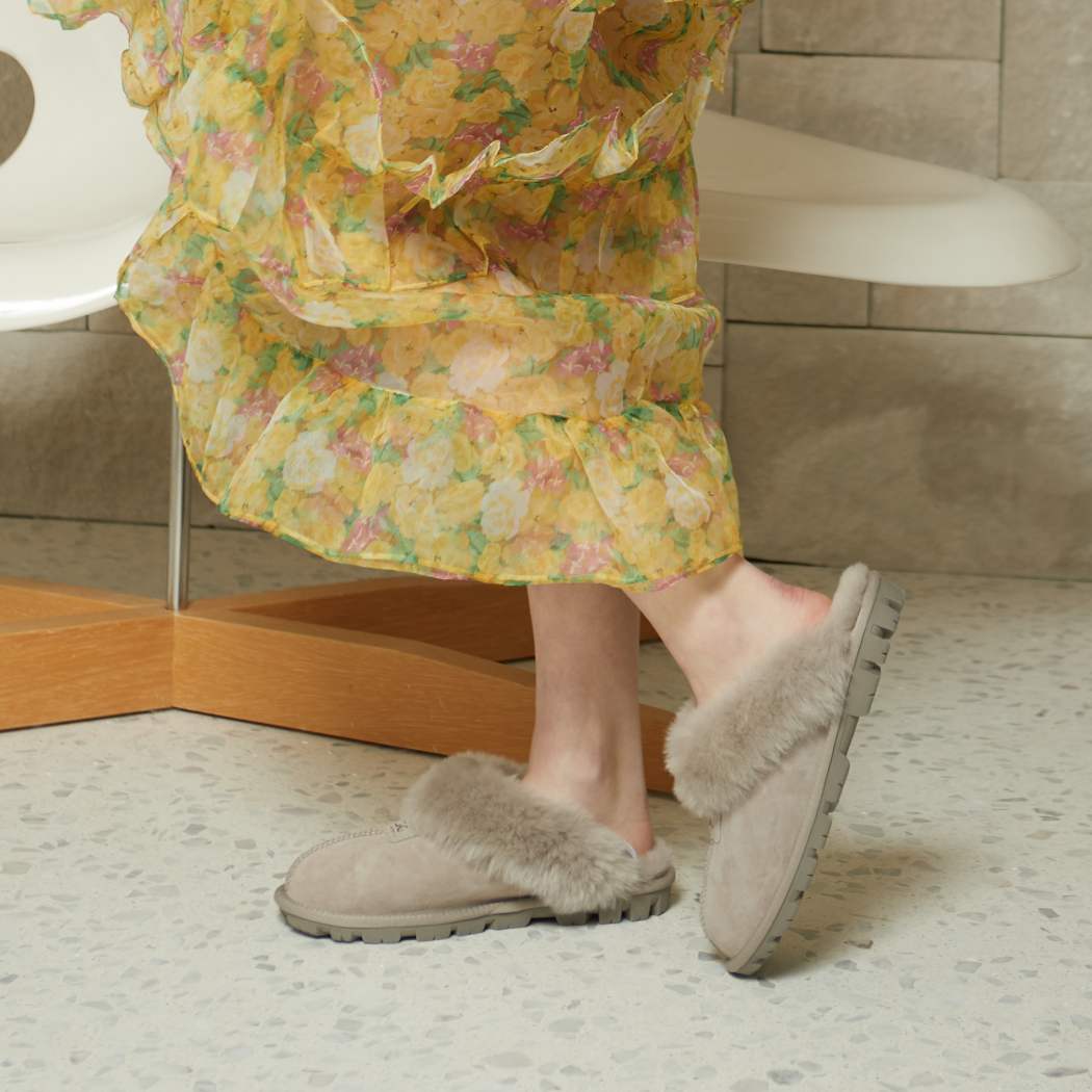 Side lifestyle view of OZWEAR UGG® Premium Australian Sheepskin Slippers OB114II showing the comfortable low-profile sheepskin design.