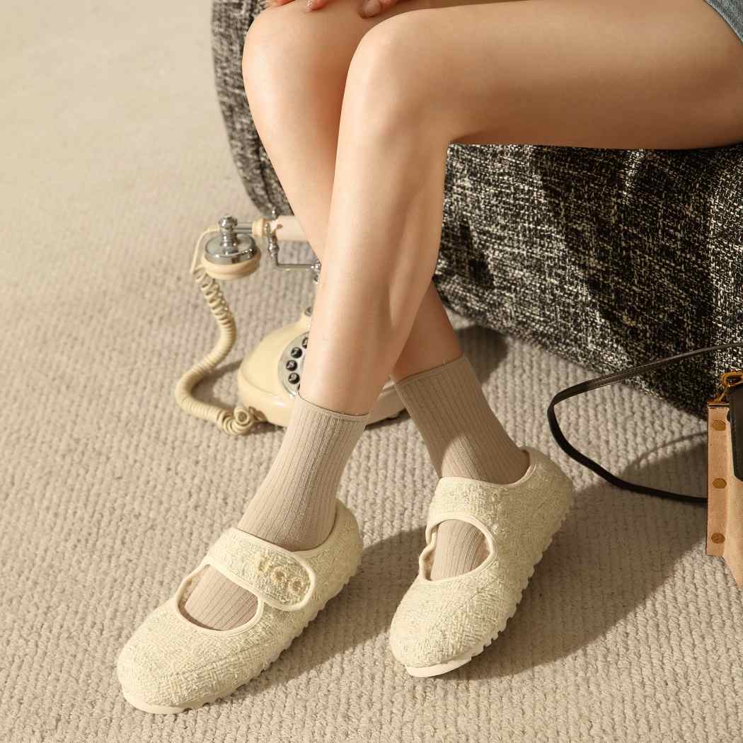 Sitting view of nude Tweed Mary Jane sheepskin wool moccasins DK 242 being worn